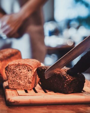 kitchen-worker-is-slicing-bread-for-lunch-W3CPK6F